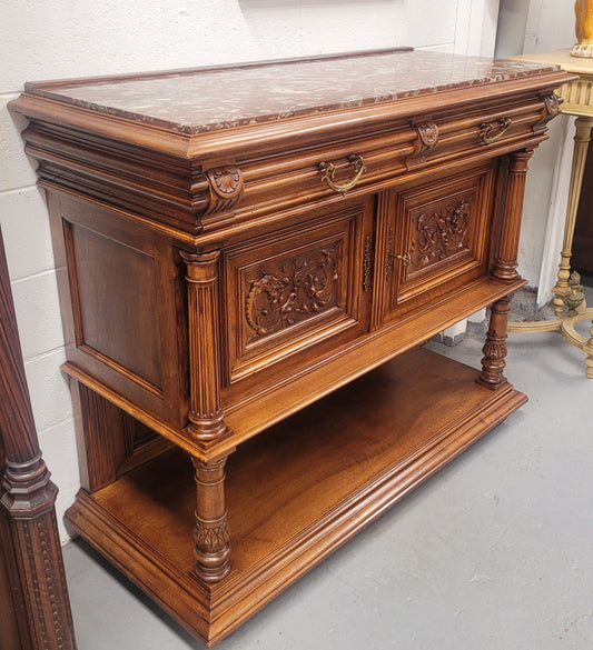 Stunning Henry II style French Walnut marble top buffet. It has a beautiful marble top and plenty of storage with two drawers, two doors with beautiful decorative carvings and an open shelf. It has been sourced from France and is in good original condition and has been detailed to a high standard.