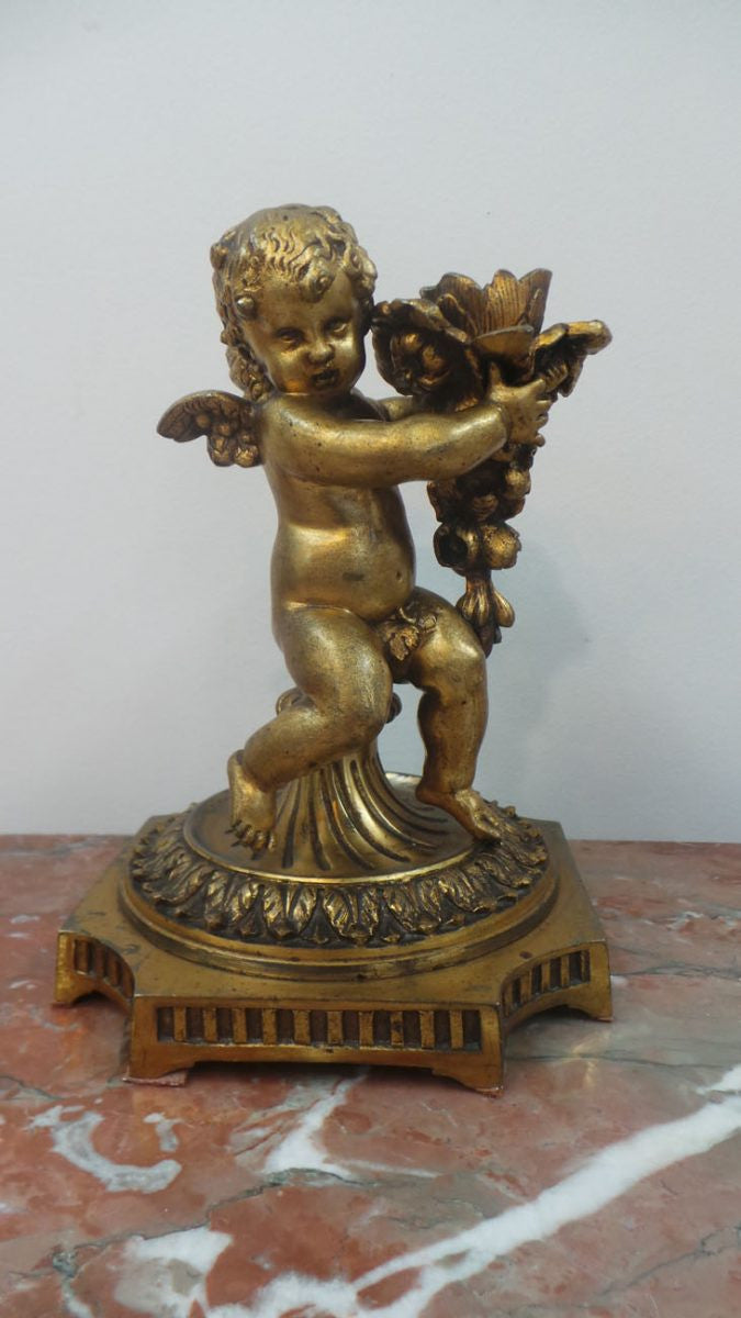 An antique signed French gilt bronze cupid candlestick in good original condition.