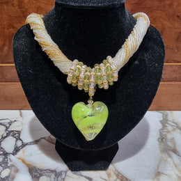 Hand Made Murano glass multi string small glass beads with medium glass beads and a large puff heart in neutral and green shades with gold. In original box.