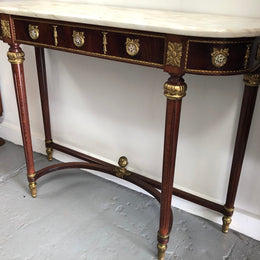 Narrow mahogany Louis XVI style console table with a marble top, ceramic inserts and gilt brass mounts.