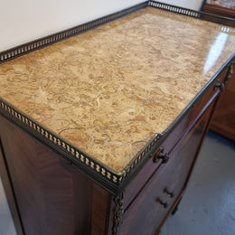 Louis 16th style marquetry inlaid side cabinet with a pierced brass gallery surrounding a marble top. It has two doors open up to storage with one shelf and a drawer above that. In good original detailed condition.
