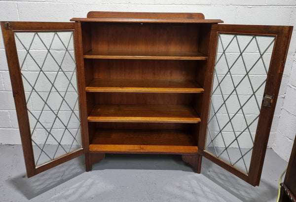 Lovely leadlight two door Oak bookcase/display cabinet with four wooden shelves. It is in good original detailed condition.