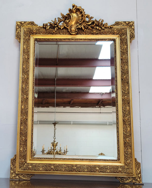 French 19th Century gilt over mantle mirror with beveled glass. In good original detailed condition.