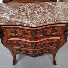 Antique French Louis XV style compact three drawer marble top commode with marquetry inlay and ormolu mounts. Sourced from France and in good original detailed condition.
