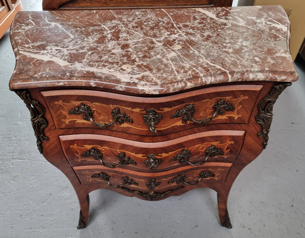 Antique French Louis XV style compact three drawer marble top commode with marquetry inlay and ormolu mounts. Sourced from France and in good original detailed condition.