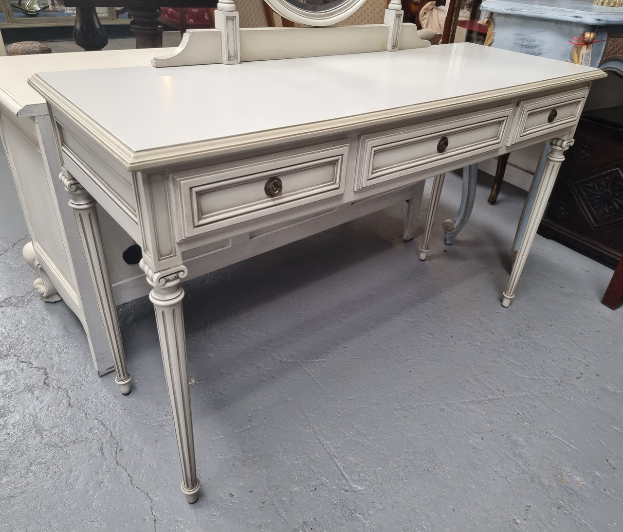 French Louis XVI style painted dresser / console with beveled oval mirror and three drawers. Sourced from France and in good original detailed condition.