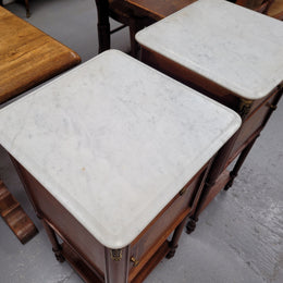 Pair of white marble topped Louis 16th style bedside cabinets consisting of one drawer and one cupboard.  Inlaid with burr walnut and has decorative mounts. They have been sourced from France and are in good original condition.
