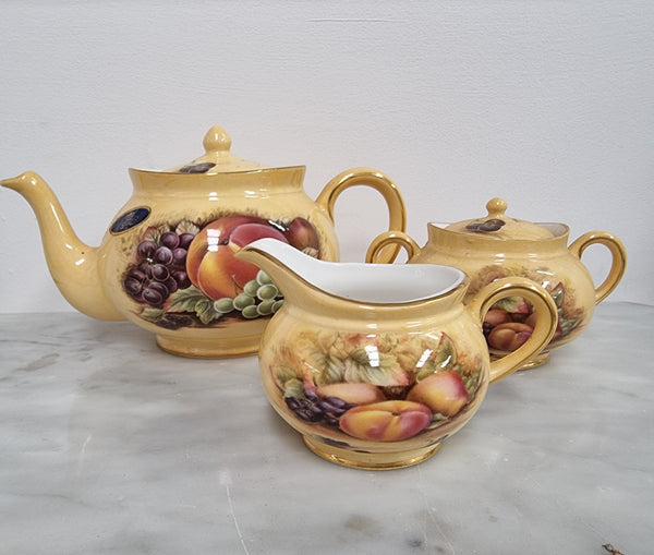 “Aynsley Orchard Gold” tea set on tray. Consisting of small teapot, lidded sugar and creamer. Please view photos as they help form part of the description.