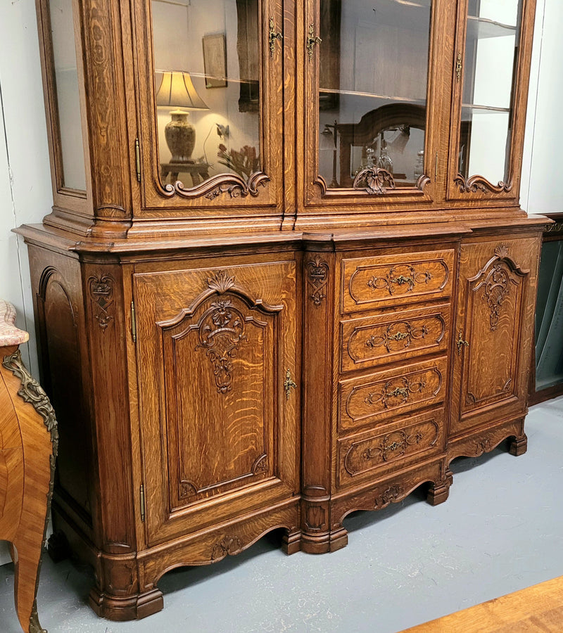 Impressive French Oak Louis 14th Style Display and Sideboard. It has 4 drawers, 2 bottom cupboards with 6 total shelves and 3 display doors with 3 shelves.  In good, detailed condition.