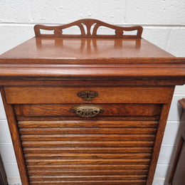 Antique Edwardian roll top Tambour file cabinet desk. This practical antique tambour front filing cabinet dates around 1900 in the Edwardian period and is constructed from Oak. This antique cabinet has an adjustable writing slope, above a tambour front with key and working lock. It has been sourced locally and is in good original detailed condition.