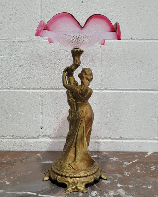 Late Victorian spelter table Centrepiece/comport featuring a woman holding an opalescent and ruby glass bowl. In good original condition with no damage to the ruby bowl.