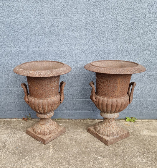 Beautiful pair of French rustic cast iron urns with handles. They would look fabulous in the garden or inside. They are very heavy an in good original condition.