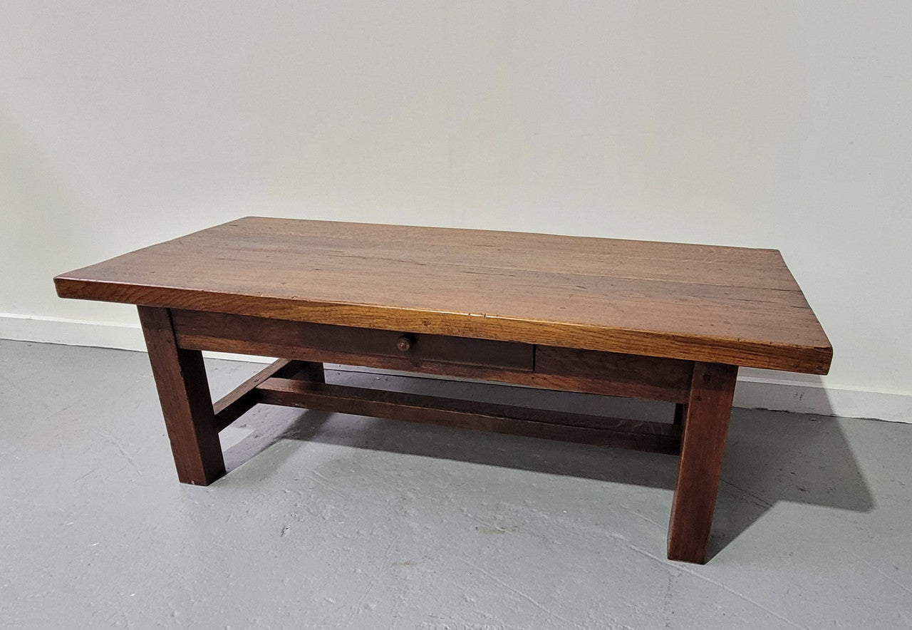 French Farmhouse style heavy Oak coffee table featuring a single drawer. In good original detailed condition.