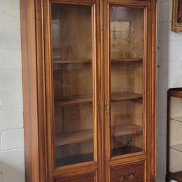 Stunning French Walnut Henry II style two door bookcase with four fully adjustable shelves. The lock on the door is functional and has a key. It is in good original detailed condition.
