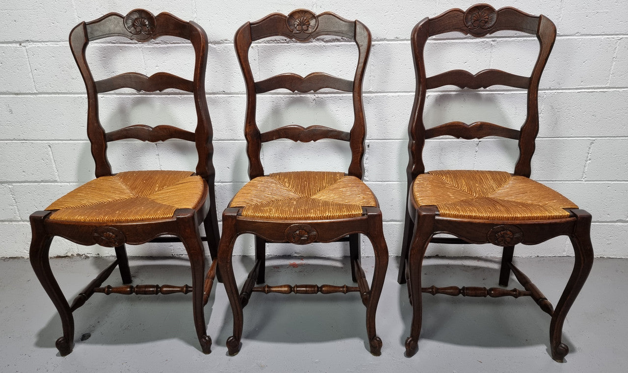 Set of six French dark Oak rush seat dining chairs with ladder back. They are in good detailed original condition and very comfortable to sit in.