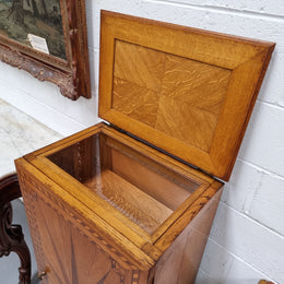 French Art Deco inlaid Oak curio/side cabinet with a lift up top and glass underneath. There are two fixed shelves, two adjustable shelves and one hidden drawer. Sourced from France and in good original condition.