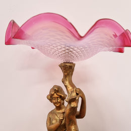 Late Victorian spelter table Centerpiece/comport featuring a woman holding an opalescent and ruby glass bowl. In good original condition with no damage to the ruby bowl.