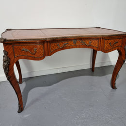 An impressive French kingwood and ormolu mounted bureau plat. It has a brown tooled leather writing surface, three decorated frieze drawers to the shaped apron with foliate swing handles and well cast figural mounts. Beautiful cabriole legs with decorative ormolu mounts and trims throughout. In good original detailed condition.