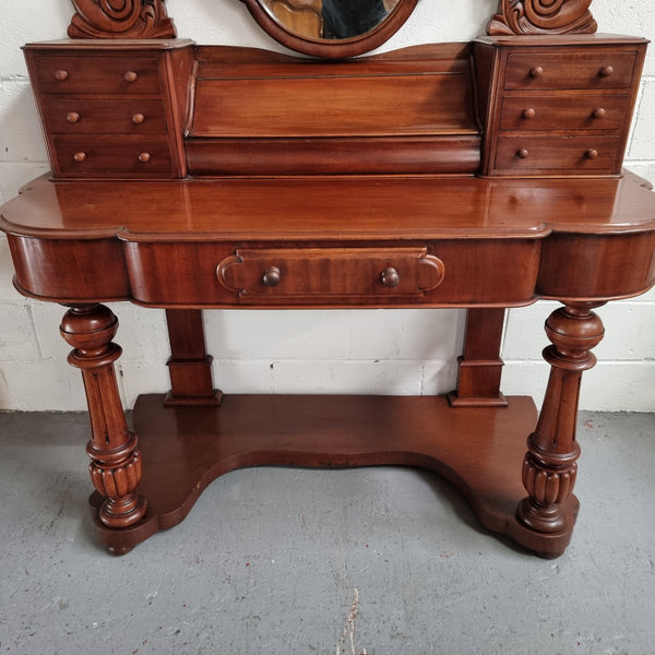 Victorian Mahogany duchess dressing table with tilt mirror on scrolled supports. It has seven trinket drawers and lift up storage. It is in good original condition and has been sourced locally.