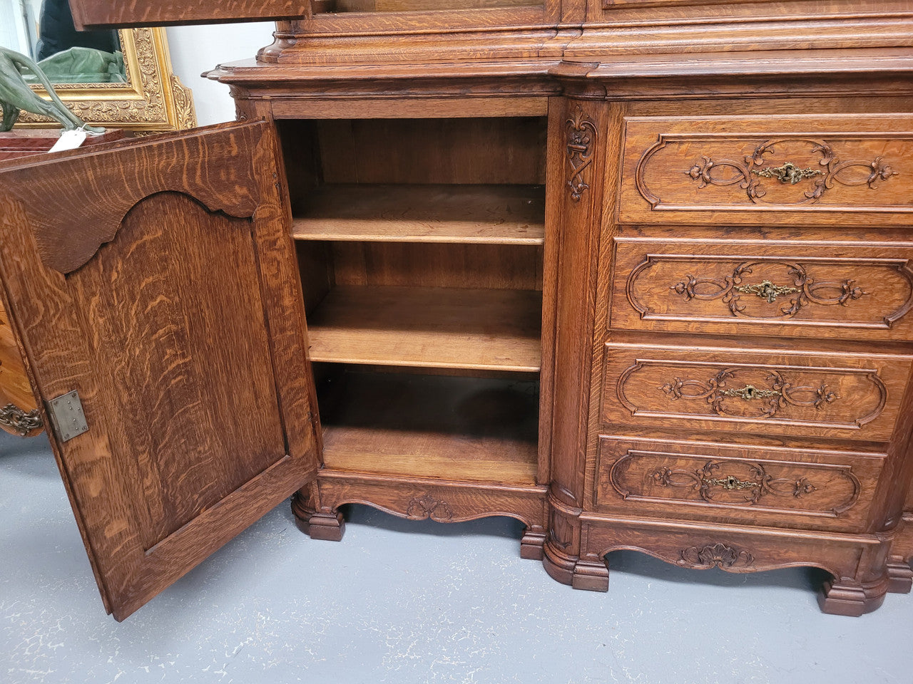 Impressive French Oak Louis 14th Style Display and Sideboard. It has 4 drawers, 2 bottom cupboards with 6 total shelves and 3 display doors with 3 shelves.  In good, detailed condition.