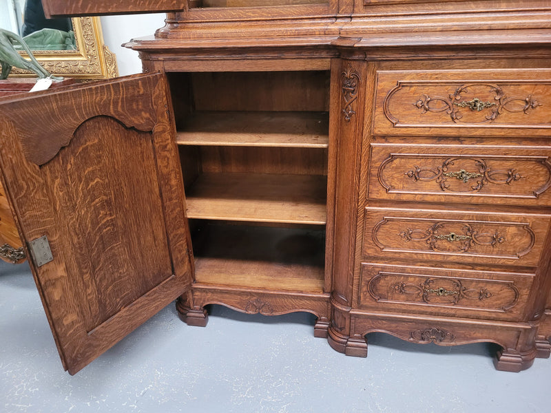 Impressive French Oak Louis 14th Style Display and Sideboard. It has 4 drawers, 2 bottom cupboards with 6 total shelves and 3 display doors with 3 shelves.  In good, detailed condition.