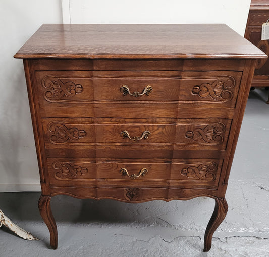 French Oak Louis XV style three drawer commode. It has been sourced from France and has decorative handles and carvings. It is in good original detailed condition.