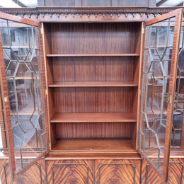 Georgian style Breakfront Flame Mahogany four door bookcase. A very impressive piece with plenty of storage and is of pleasing narrow proportions. It has been sourced locally and is in good original detailed condition.