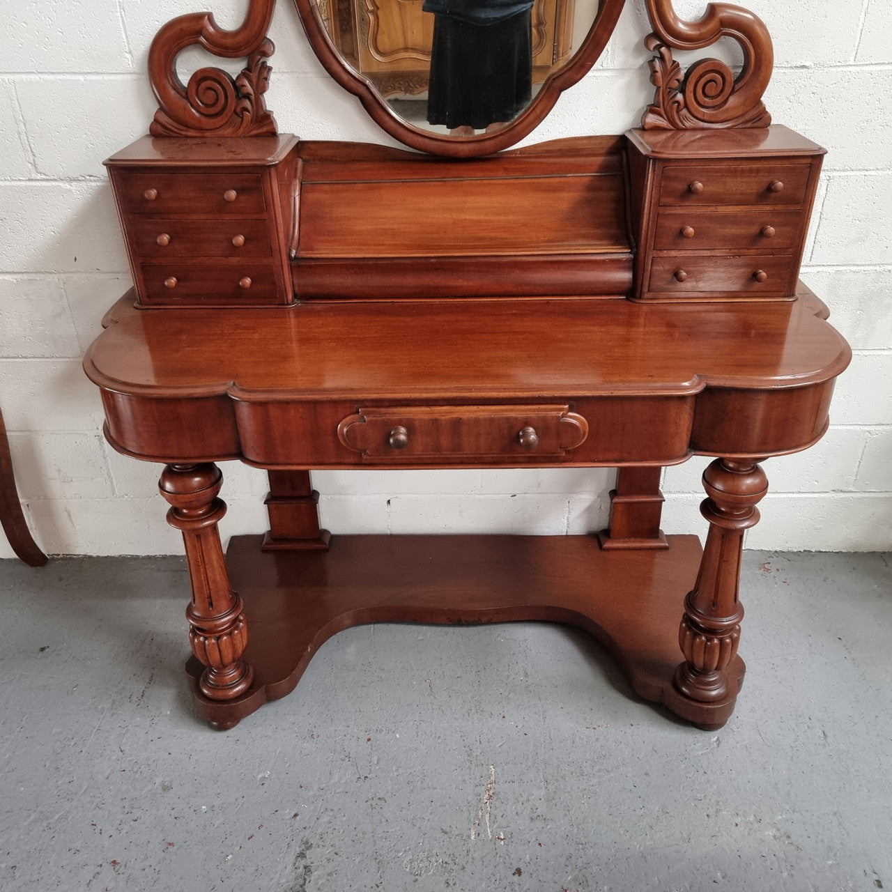 Victorian Mahogany duchess dressing table with tilt mirror on scrolled supports. It has seven trinket drawers and lift up storage. It is in good original condition and has been sourced locally.