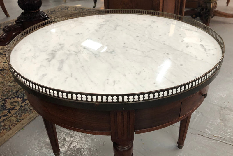 Large French Bouillotte table with a marble top and brass fitted gallery. It has two concealed leather - topped slides and two drawers and in good original condition.