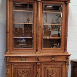 Amazing French 19th Century Oak two-door bookcase. Amazing detailed carvings throughout and plenty of storage space with three adjustable shelves at the top, two drawers, and a further shelf at the bottom. Also has two pull out reading slides giving you a large area to view your books on. In very good original detailed condition.