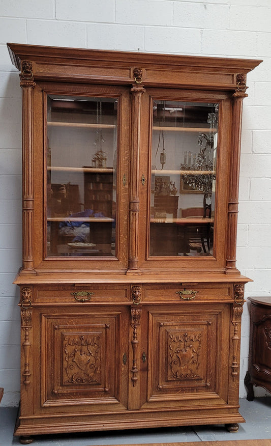 Amazing French 19th Century Oak two-door bookcase. Amazing detailed carvings throughout and plenty of storage space with three adjustable shelves at the top, two drawers, and a further shelf at the bottom. Also has two pull out reading slides giving you a large area to view your books on. In very good original detailed condition.
