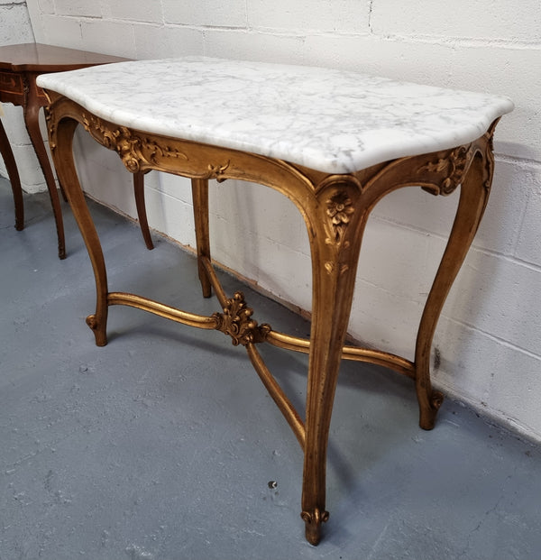 French Louis XV style carved center table with a stunning marble top and original gilt. In good original detailed condition.