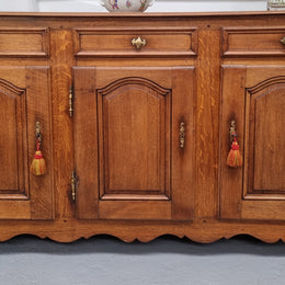 French Oak early 19th century three door buffet. It has a classic simple look and has three cupboards and three drawers. It is in good original detailed condition.