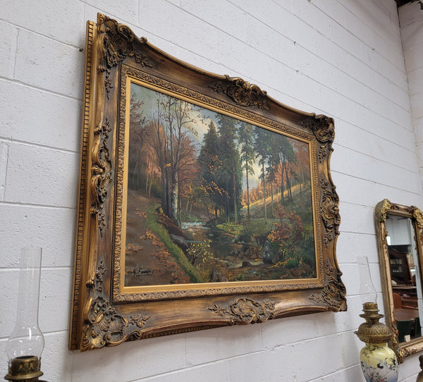 Large signed oil on canvas depicting a river stream in autumn framed in a stunning gilt frame. Sourced from France and is in good original detailed condition.