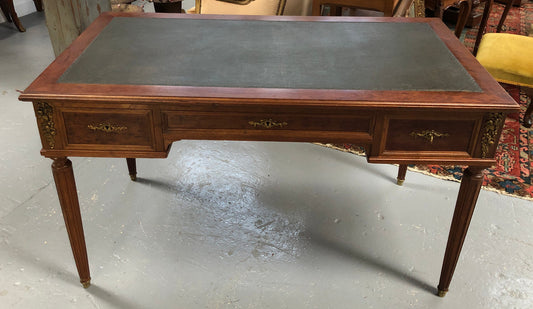 Lovely French Mahogany Louis XVI style leather top desk. With beautiful ormolu details and three drawers. There are also two slides on either side with tooled leather tops and in good original detailed condition.