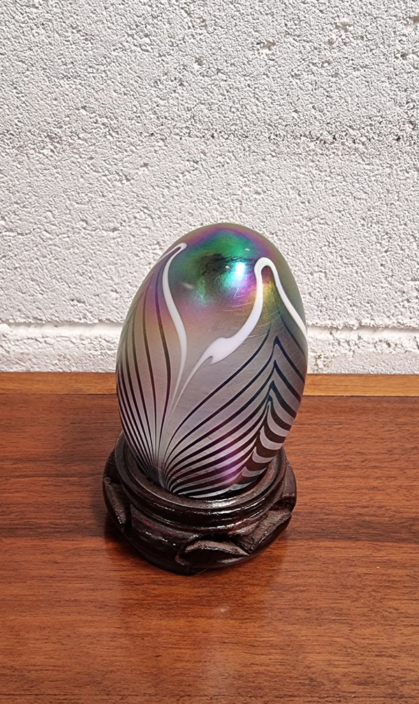 Iridescent glass egg shaped paper weight, on small wooden chinese stand. In good original condition. Please see photos as they form part of the description.