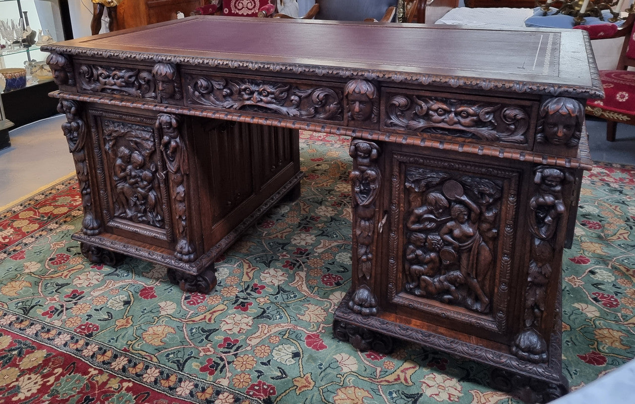 Beautifully carved French Oak early 19th century pedestal desk with 3 drawers, two cupboards and a secret cupboard on the side. There is also a lovely burgundy tooled leather top. In good original detailed condition.