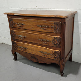 A French Walnut carved three drawer commode with lovely handles and in good original detailed condition.