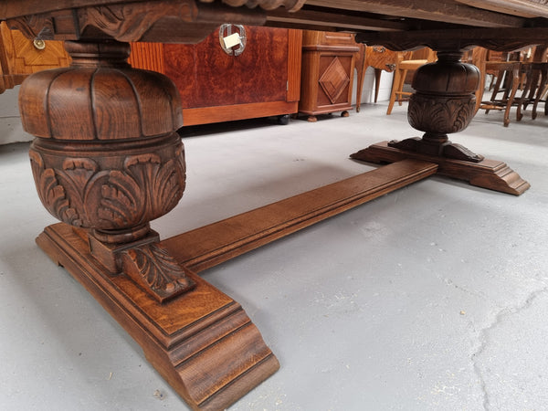 French Oak Renaissance style extension table with a stretcher base and heavily carved bulbous. When the table fully extends it measures 300 cm and can be used with both sides out or with only the one leaf out either side. It is in good original detailed condition.
