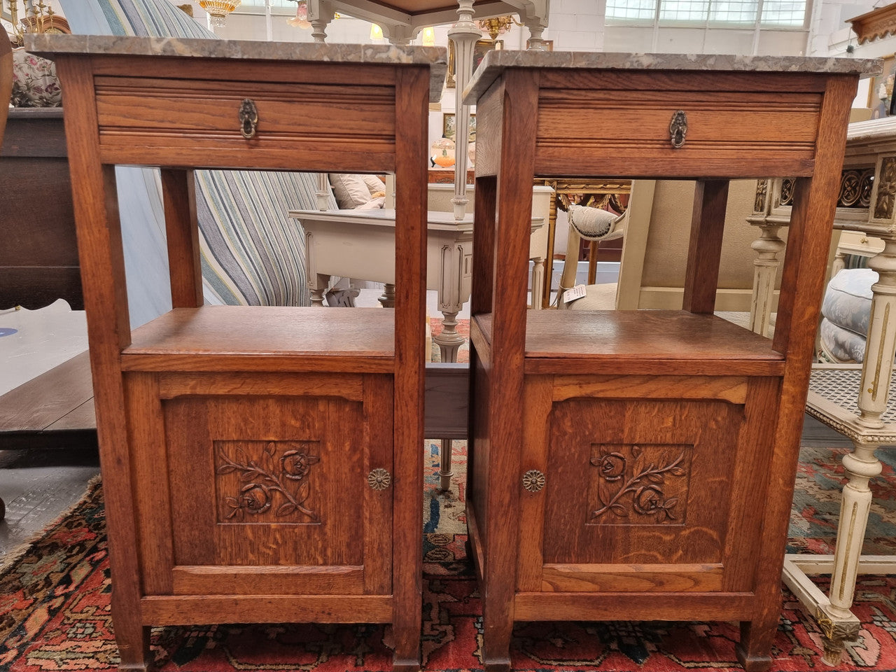 Charming pair of French Oak Arts and Crafts bedsides with shelf, cupboard with carving and marble top.  They have been sourced from France and are in good original detailed condition.