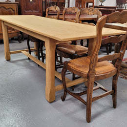 French raw Oak stretcher based refectory table. Features raw wood that could be used as is for a distressed look, or finished and waxed for a more refined look. Sourced from France and in good original condition.