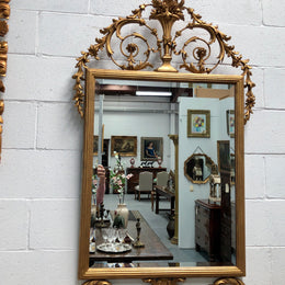 Mid 20th Century Italian gilt wood framed gold wall mirror. Highly decorative carving with a bevelled mirror. Is in good original condition.Mid 20th Century Italian gilt wood framed gold wall mirror. Highly decorative carving with a bevelled mirror. Sourced directly from France and is in good original condition.