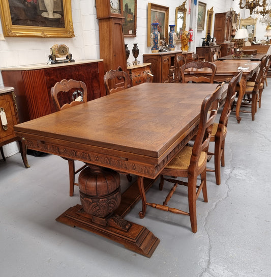 French Oak Renaissance style extension table with a stretcher base and heavily carved bulbous. When the table fully extends it measures 300 cm and can be used with both sides out or with only the one leaf out either side. It is in good original detailed condition.