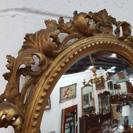 Large round carved wooden convex mirror. Still contains its original mirror which shows signs of aging.