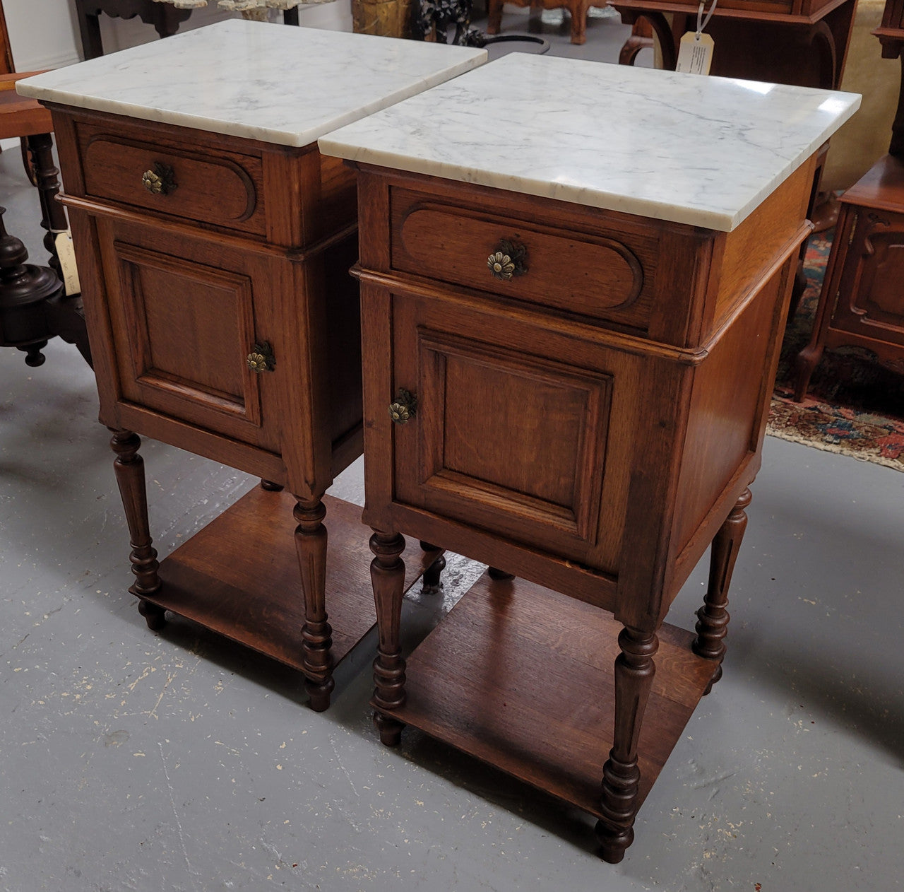 Antique French Oak Henry II white marble top bedside cabinets. They have one drawer and cupboard a long with an open shelf at the bottom. Sourced from France and in good original detailed condition.