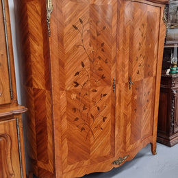 Charming French Louis XV Style Marquetry Inlaid Two Door Armoire. Features three adjustable shelves and ormolu trim. It has been sourced from France and is in good original condition.
