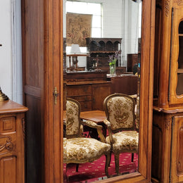 French Louis XV style Walnut armoire with single bevelled mirrored door. It has four adjustable shelves and a hidden exterior drawer at the bottom. It has been sourced from France and is in good original detailed condition.