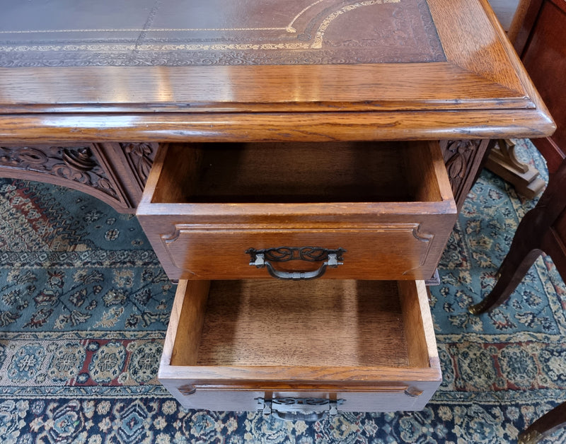 Substantial French Louis XVI style Oak partners desk. It has a beautiful leather top, two drawers on either side and decorative carvings throughout. Sourced from France and in good original detailed condition.