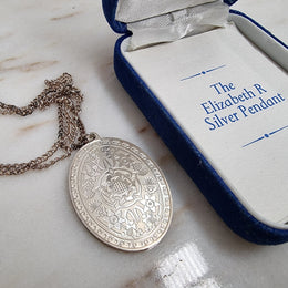 Attractive oval-shaped sterling silver ingot pendant issued by Franklin Mint in 1977 to commemorate Queen Elizabeth II Silver Jubilee. It comes with its original box and paperwork.