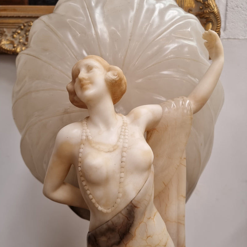 Monumental Art Deco alabaster and marble figural lamp modelled as a seductively dressed semi naked woman. In subtlety coloured diaphanous robes with a large clam shell light backdrop. Italian circa 1920's signed to base. This is a world class example of a true Art Deco sculpture lamp. It is in good original detailed condition, please view photos as they help form part of the description.